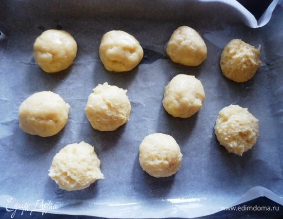 Готовое тесто поместить в кондитерский мешок и отсадить профитроли на противень, покрытый бумагой для выпечки.