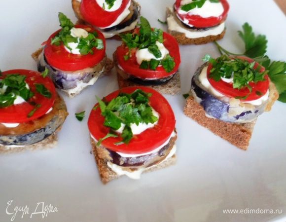 На хлеб намазать сметанно-чесночную смесь, положить кругляшочек баклажана, снова сметанная смесь, кружочек помидора, сверху капнуть сметанную смесь и посыпать рубленной петрушкой