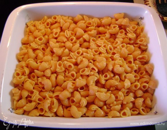 Выложить отварные макаронные изделия на дно огнеупорной формы. 