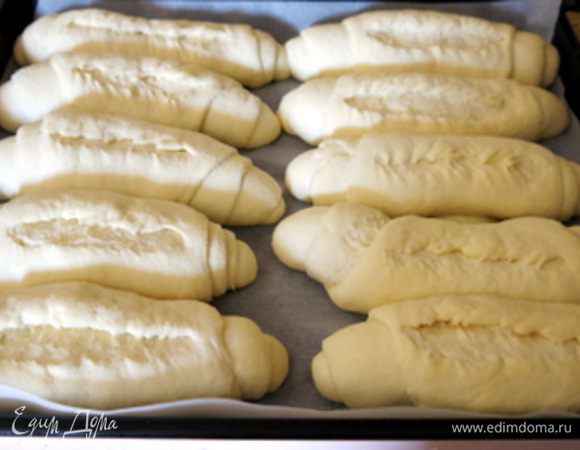 Нагреть духовку до 200-220°. На булочках сделать надрез,держа очень острый нож (или лезвие бритвы, как делают в Риме) под углом, а не перпендикулярно булочке.
