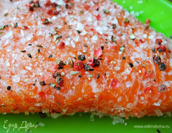 Всё очень просто: ополоснуть кусочек форели и просушить бумажным полотенцем. Положить в форму, посыпать солью, свеже-крупно-молотым черным перцем, немного втереть их в мякоть рыбы (нежно). Затем посыпать розовым перцем . 