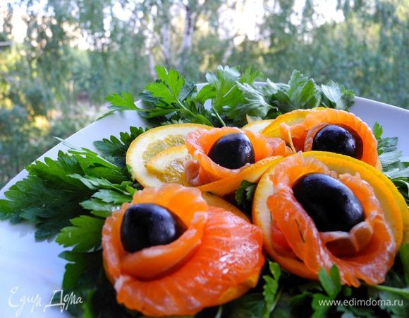 Затем вынуть из холодильника, очистить от  "шубы", нарезать тонкими ломтиками. Если понравился вариант подачи, то этими ломтиками обернуть оливки и "упаковать" в кулечки из кружочков апельсинов. На зелени, конечно, будет смотреться наряднее)))