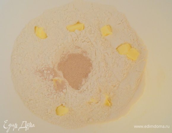 В центре сделать лунку и всыпать туда дрожжи