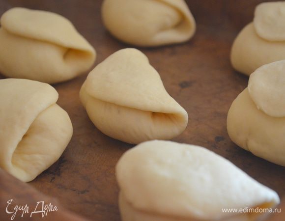 противень застелить бумагой для выпечки, смазать ее растительным маслом и выложить на нее булки. Присыпать их мукой и затянуть пищевой пленкой. Оставить на 40 минут - за это время они должны вырасти