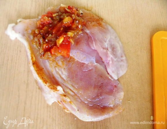 На край куриной грудки положить луково-помидорную смесь