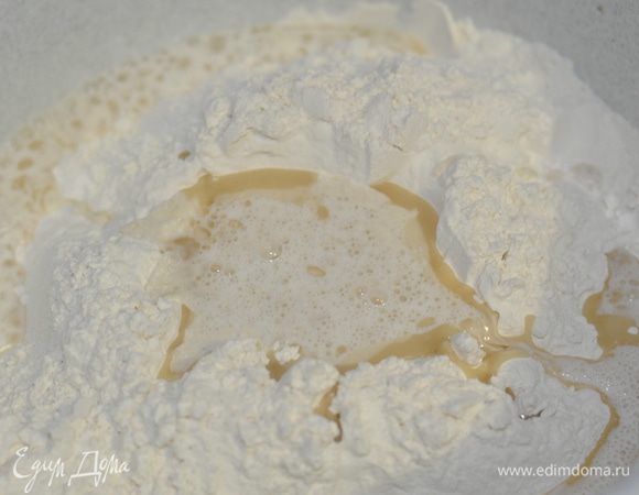 В лунку муки влить растительное масло, подошедшие дрожжи и щепотку соли.