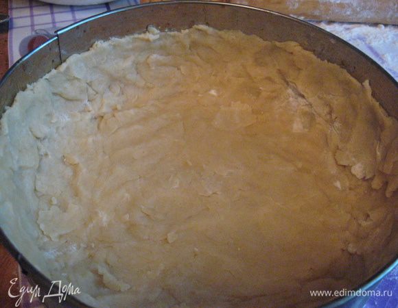 Дно формы выстилаем пергаментной бумагой, бока смазываем маслом.  Тесто раскатываем немного, а дальше руками распределяем по форме. Делаем высокие бортики. И ставим в морозилку до тех пор, пока не будем выкладывать начинку.
