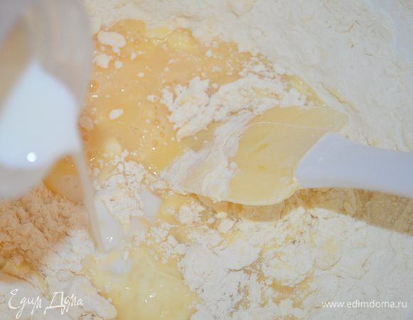 Влить яйца в муку  и все размешать. Добавить молоко, ванильный сахар, обычный сахар и замесить мягкое тесто. 