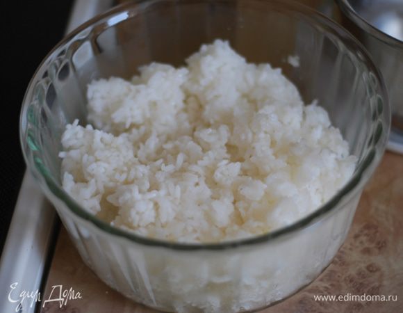 Выложите рис в миску и режущими движениями аккуратно перемешайте его деревянной лопаткой. Дайте рису немного остыть, тем временем подготовьте начинку и нори.