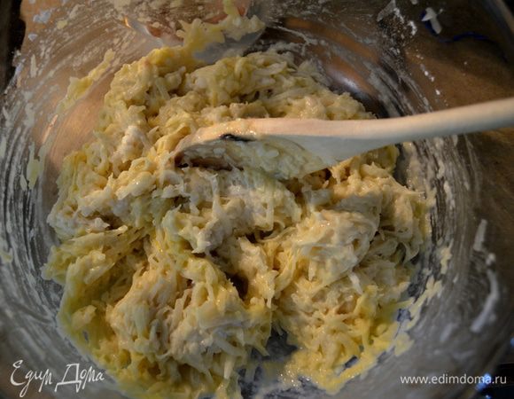 Добавим в картофель муку, крахмал, соль и белый перец, желток. Все перемешаем. Предварительно достанем горячий противень, смажем его 2 стол. л. олив. масла. Отставим в сторону. 