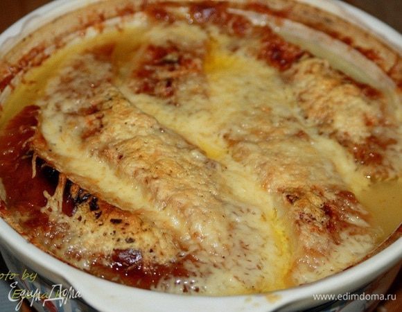 Лук обжарить в  сковороде в хорошо нагретом масле на средне-сильном огне до карамельного цвета, посолить, добавить чайную ложку сахара. 

Увеличить огонь до средне-сильного, всыпать муку, обжарить минуту, влить вино и половник бульона, прогреть,  влить остальной бульон, довести до кипения, готовить 10 минут, посолить. 

Суп разлить по керамическим горшочкам (у меня керамическая кастрюля).  Сверху выложить по 1-2 ломтика подсушенной в духовке булки,  посыпать тёртым сыром.
 
Запекать под грилем до образования румяной корочки. 