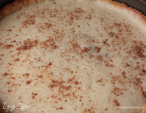 Тем временем на среднем огне подогреть сливки с молоком с вскрытым ванильным стручком в соуснике пока по краям кастрюльки не начнуть появляться пузырьки. В то время когда сливки накреваются, взбейте яйца и желтки с сахаром, вылейте в горячие сливки постоянно взбивая, затем просейте через сито в миску введите мускатный орех. Влейте в приготовленное тесто для тарта, натрите сверху дополнительно мускатный орех и отправьте в духовку. 