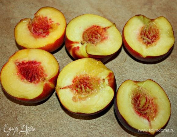 Персики разрезать пополам и вынуть косточки.