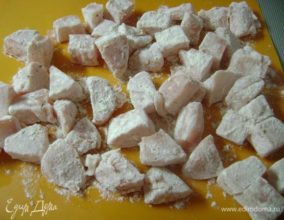 Куриные грудки нарезать кубиками и обвалять их в муке, стряхнув излишки.