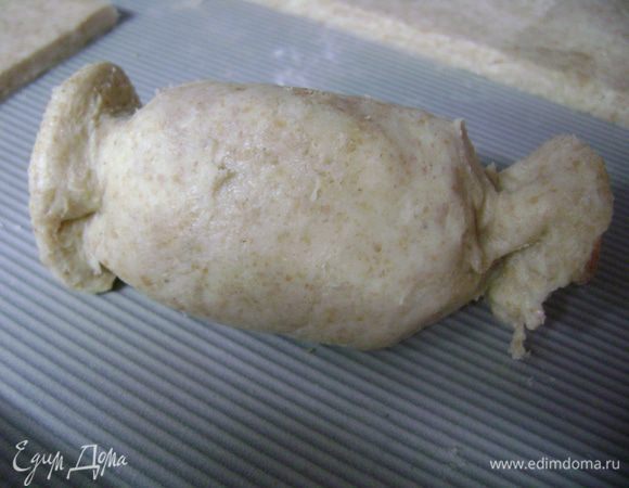 Тесто (лучше частями, иначе масло тает и работать с тестом труднее) раскатать на посыпанной мукой рабочей поверхности, разрезать на прямоугольники. В половинку яблока вложить чернослив, их вместе уложить на прямоугольник теста и завернуть шубкой. Концы можно защипить или придать любую форму.