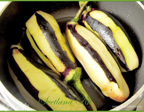 Баклажаны промыть и частично очистить полосками, хвостики не отрезать. Обжарить целые баклажаны с двух сторон в разогретом растительном масле. Жарить до мягкости.