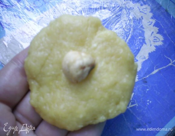 Берем кусочек теста размером с грецкий орех, расплющиваем его и кладем в серединку орешек или несколько изюминок.