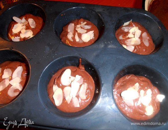 Силиконовую форму смачиваем водой (так написано в инструкции), маслом не смазываем! Заполняем тестом на 2/3 каждую ячейку. Сверху слегка присыплем хлопьями.