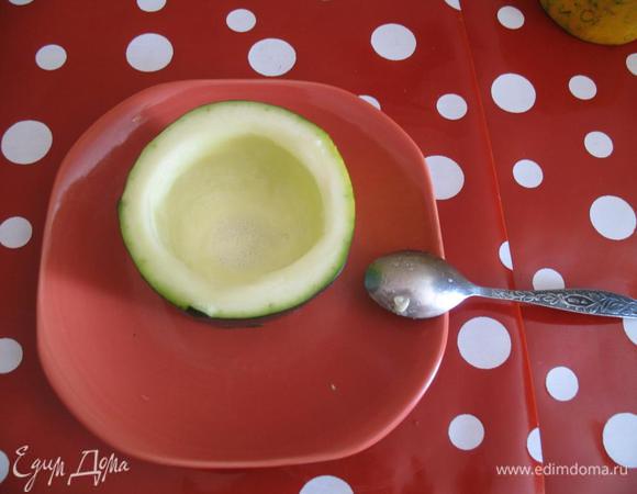 Затем при помощи чайной ложки вынимаем часть мякоти с семечками — так, чтобы в результате получился полый стаканчик с донышком.

