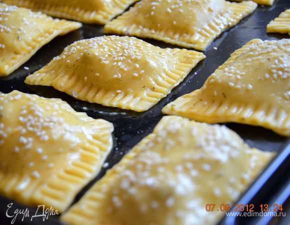 На прямоугольник выложить около 1-1,5 ст. л. начинки. Смазать края взбитым яйцом. Накрыть вторым прямоугольником. Придавить слегка края и при помощи вилки защипать. Выложить на противень. Смазать взбитым яйцом (я во взбитое яйцо добавила немного сухого укропа). Присыпать кунжутом и слегка присыпать крупной морской солью, только не переборщите  с солью). 