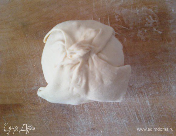 Пласт слоеного теста  разделить на 2 части. Одну из этих частей еще раз разделить на две части. Затем тонко раскатать  полученные 3 части  -
 квадратом. В центр квадрата разместить яблоко. Засыпать в сердцевину  орехи с изюмом и залить медом. Соединить концы квадрата и зажать пальцами в хвостик. Смазать поверхность теста желтком.