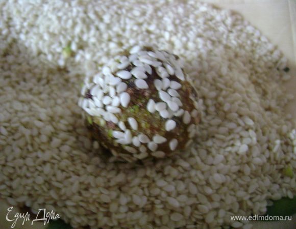 Сформировать шарики размером с грецкий орех или ещё меньше, обвалять половину в кунжуте, половину в рубленых фисташках. 