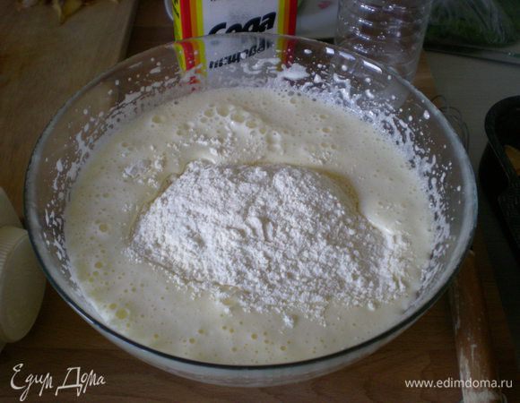 Добавьте муку и соду, погашенную уксусом. Хорошо перемешайте миксером тесто, чтобы не было комочков.