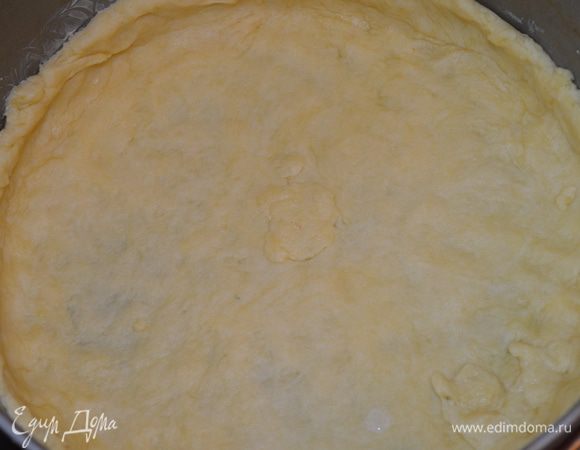 Тесто раскатайте в пласт и переложите в разъемную форму диаметром 24 см, сделайте бортики высотой 2–3 см.