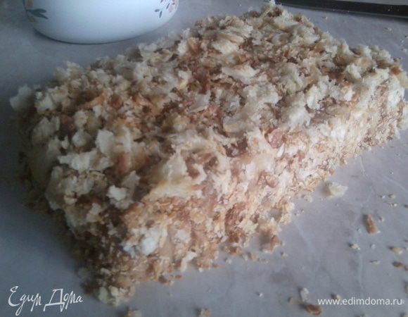 Торт вынуть из формы и освободить от фольги (бумаги, плёнки).
Обвалять торт в крошках.