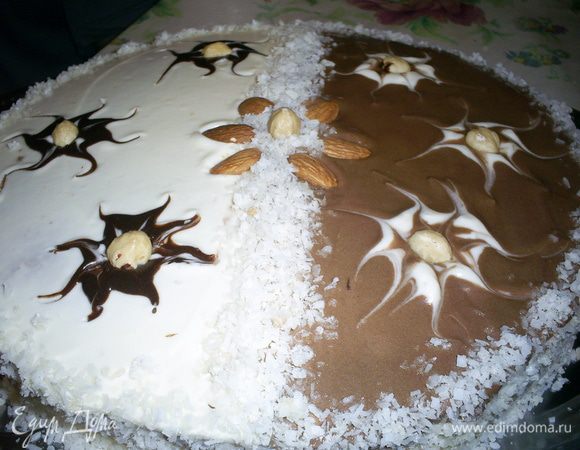 Приступаем к сборке торта. Корж с карамельной пропиткой прямо поверх нее щедро смазываем кремом. Накрываем вторым коржом,обмазываем  бока торта. В оставшийся крем добавляем ложку какао и тщательно перемешиваем. Смазываем поверхность торта кремом. А можно сделать праздничный вариант. Тогда одну половину поверхности смазываем белым кремом, другую шоколадным. На шоколадной поверхности чайной ложкой наносим три точки белым кремом и зубочисткой рисуем разводы. Делаем то же самое на белой части шоколадным кремом. Чтобы крем был ярче я добавила два кубика расплавленного черного шоколада. Бока торта по желанию обсыпаем кокосовой стружкой. Даем торту пропитаться хотя бы пару часов и наслаждаемся вкусом. Приятного аппетита!