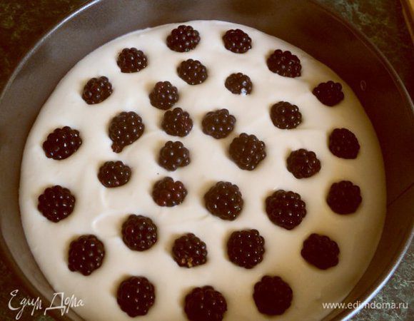 Выложить на корж половину сметанного крема, сверху разложить ягоды ежевики.