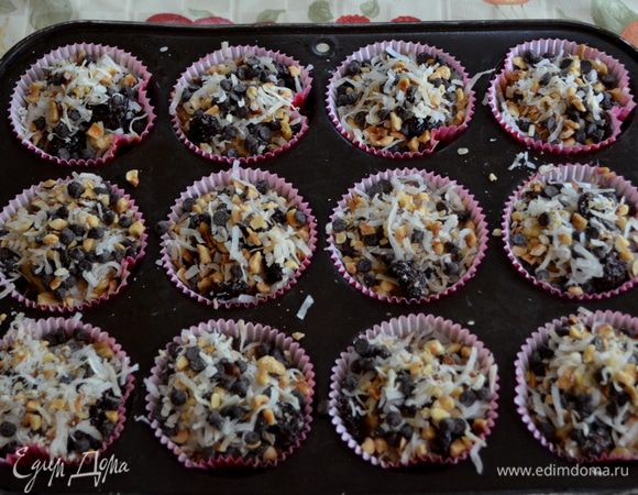 Разложим тесто по бумажным стаканчиком ,каждый заполняем 1/3,тесто поднимется.И выложим сверху оставщуюся смесь кокосов.стружки  в каждый стаканчик по одиннак.порции.