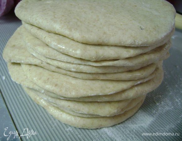 Смазать сливочным маслом лепешку и отложить в сторону. Так поступаем со всем тестом, складывая лепешки друг на друга в стопочку. Последнюю лепешку не смазывать маслом, а уложить сверху на стопочку.