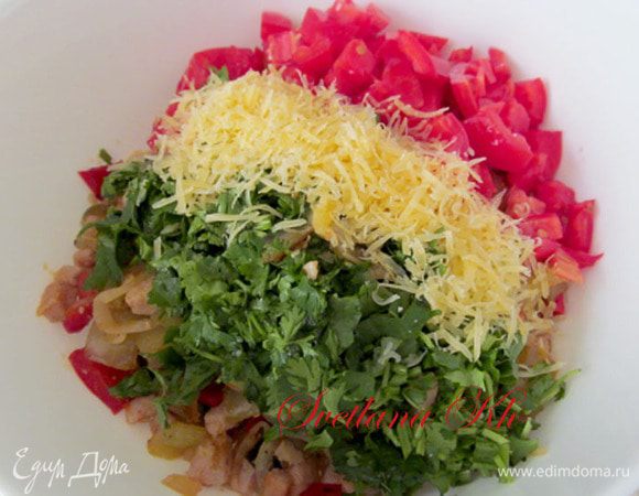 Снять с огня, слегка остудить. Добавить мелко нарезанные помидоры, чеснок, петрушку и половину натертого сыра. Все смешать.