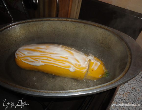 В утятницу налить немного воды и подсолить. Дать, чтобы она закипела. Выложить кабачок, смазать сметаной. Тушить под крышкой 40 минут.