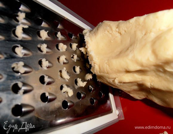 Настала очередь кусочка теста,который мы припрятали в морозилке.Не давая ему нагреться,быстро натираем его на крупной тёрке над начинкой!(если оттаяло,то часть снова кидаем в морозилку)