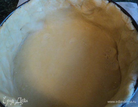 Дно формы для выпечки застелить бумагой для выпечки, смазать маслом. Выложить пласт теста, сформировав бортики.