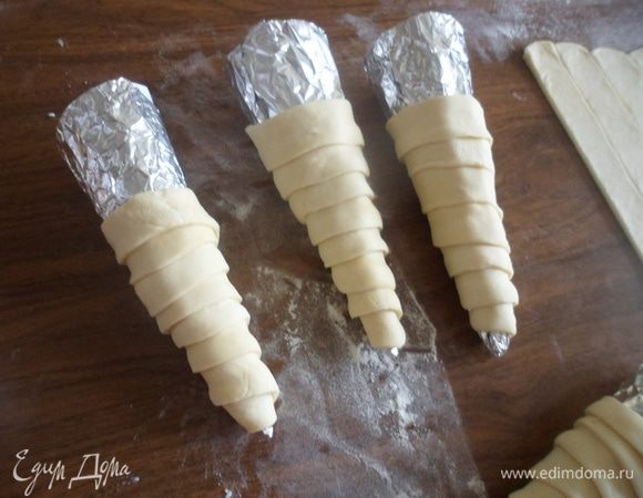 Готовые полоски необходимо аккуратно накрутить на конусы, которые используют при выпечке трубочек, или сделать, как я: скрутить кулечки из бумаги и обернуть их фольгой