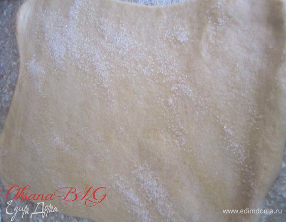 Готовое тесто раскатать в пласт толщиной примерно 2 см. Немного смазать водой, посыпать сахаром, скатать в двойной рулетик или же в простой рулет.