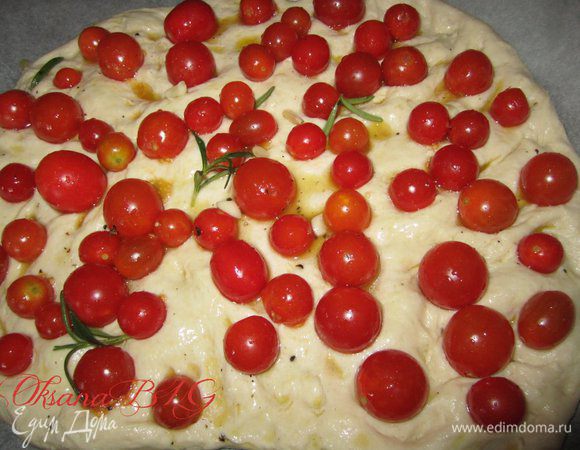 Выложить помидоры, вдавив их в тесто, сверху полить оливковым маслом из помидор.