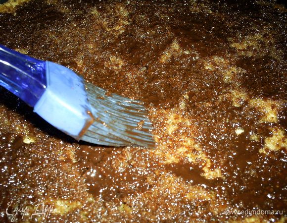 Тем временем растопим шоколад с маслом на водяной бане, немного остудим и добавим коньяк. Полученной массой с помощью кисточки промазываем коржи и оставляем, чтобы прослойка застыла.