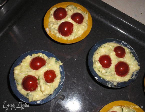 Накладываем тесто в формочки для кексов на 2/3 высоты. Помидорки черри выкладываем сверху, слегка вдавливают в тесто.