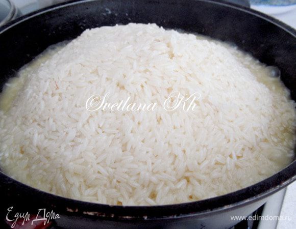 Как только верхушка стала сухой, собираем рис горкой к середине казана, перемешивая только верхний слой, не задевая морковь и мясо.По краям еще будет немного жидкости и масла. Накрываем крышкой и уменьшаем огонь до минимального. Ждем 15 минут.