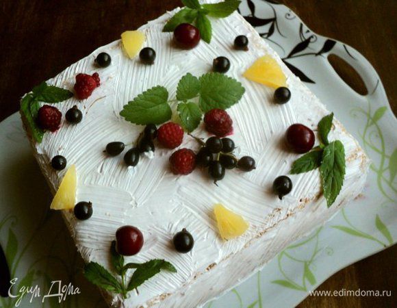 Покрыть взбитыми сливками бока и верх торта, нанести узор (я наносила узор кисточкой). Сверху украсить торт фруктами и листиками мяты.