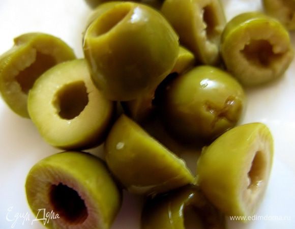 Несколько оливок режем пополам.