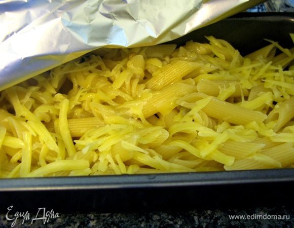 Когда макароны дойдут до нужной нам кондиции (у меня это заняло 3-5 минут после того, как я их бросила в кипящую воду), мы укладываем их в жаропрочную форму, добавляем к ним оливки, выжимаем половинку лимона, добавляем 1/3 стакана белого сухого вина и присыпаем сыром. Перемешиваем. Отправляем в духовку.