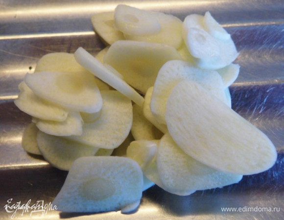 Помидоры разрезать пополам, чеснок нашинковать "лепестками".

