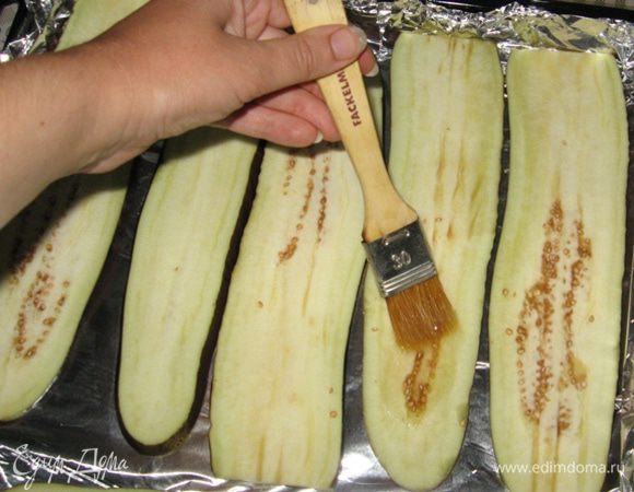 Баклажанам отрезать "хвостики" и нарезать вдоль достаточно тонкими пластиками. Маленькие корявенькие боковинки я прибрала в морозилку для следующих готовок.
Противень выстилаем фольгой, смазываем ее растительным маслом, выкладываем баклажаны. Сверху баклажаны смазываем маслом с помощью кисти. Так они и пропекутся и маслом не пропитаются особо. Ставим в духовку на 180 градусов минут на 10 - 15 (зависит от толщины ломтиков).