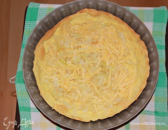 Вынуть форму с тестом из холодильника. На дно уложить ровным слоем оставшуюся половину сыра. 