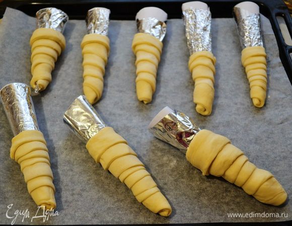 Тесто немного раскатать и нарезать его на длинные полосы. Полоски теста накрутить спирально по конусу. И уложить на противень, застеленный бумагой. Выпекать при 190 гр 25 мин.